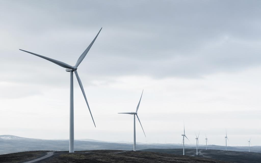 Utility-scale wind turbines on an open plain under an overcast sky